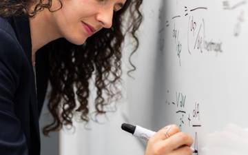 Girl writing algorithm in a blackboard